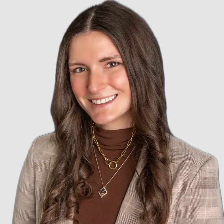 Smiling person wearing a plaid blazer.